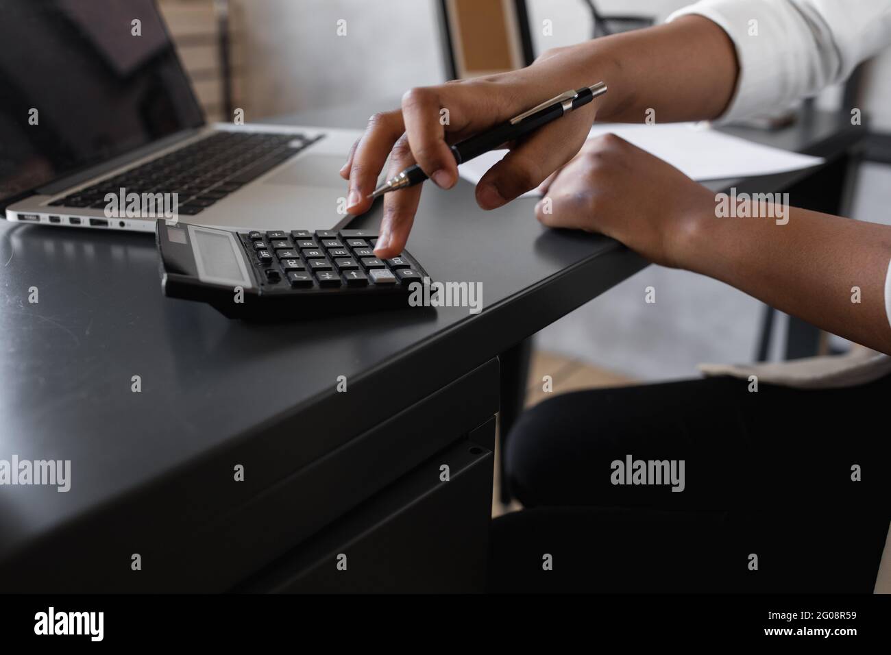 black business woman counts on a calculator and makes notes. financier or accountant works from home Stock Photo