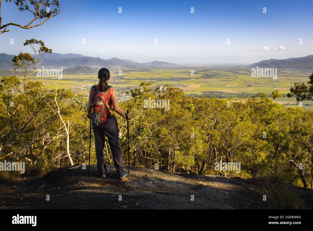 A female hiker with backpack and hiking poles stands atop the Pyramid