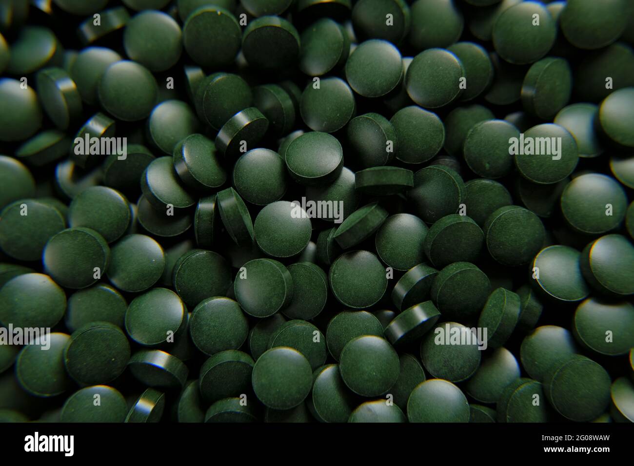 Spirulina green pills background. Spirulina algae green tablets. Food supplements for a healthy lifestyle  Stock Photo