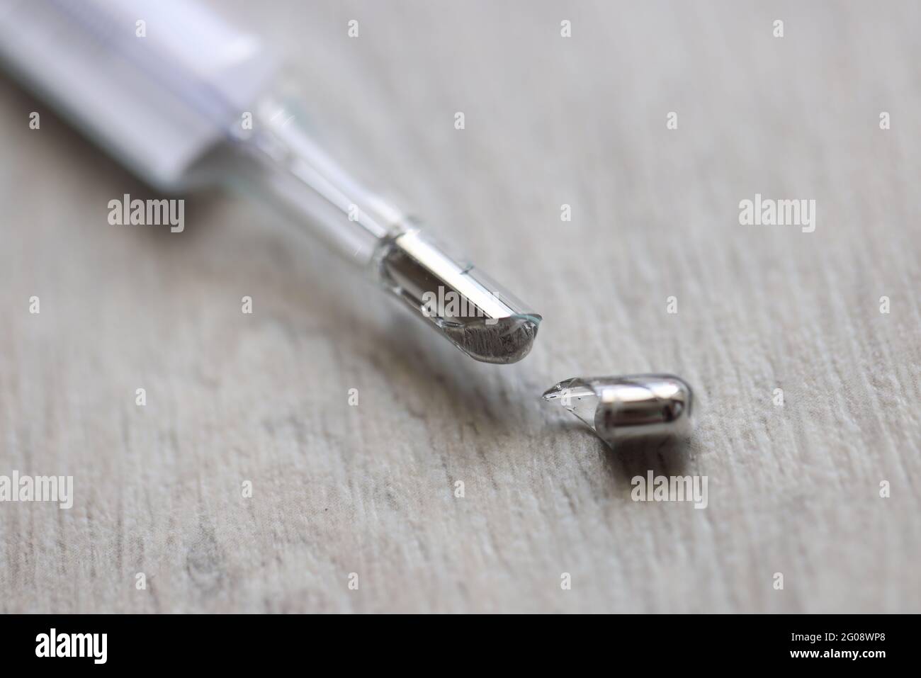 Broken mercury thermometer lies on floor closeup Stock Photo - Alamy