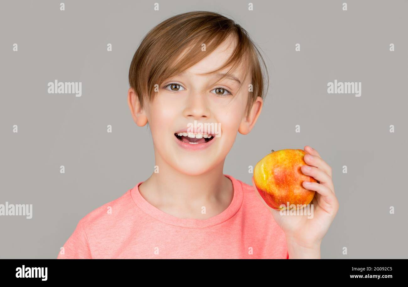 Little boy eating apple. Boy apples showing. Child with apples