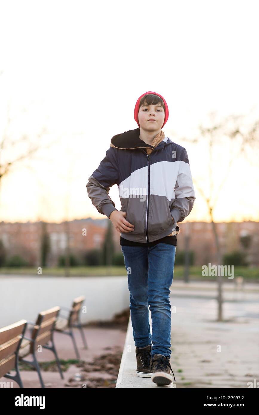 Stylish handsome teen boy wearing denim jacket and knit hat over city background close up Stock Photo