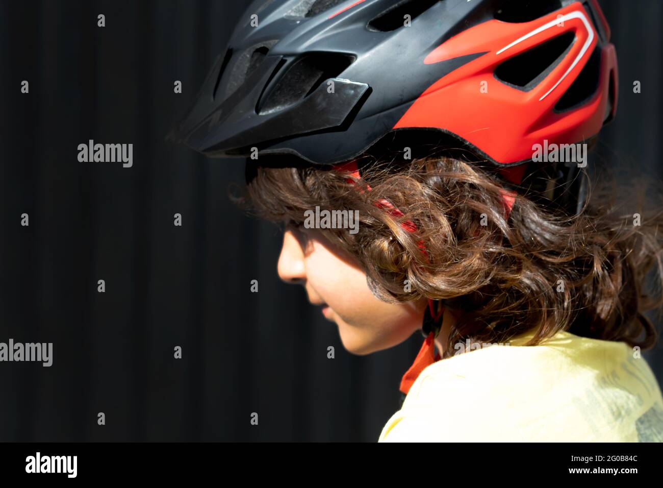 Profile photo of a little boy with long hair wearing a safety