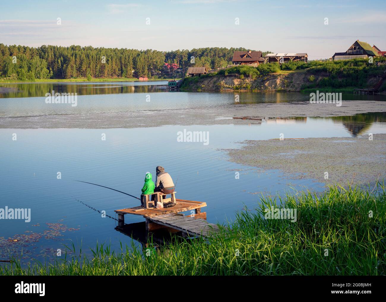 Back view of grandfather and grandson with fishing chair and