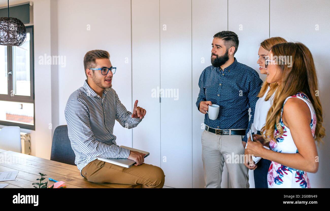 Young team leader in an informal meeting explaining project Stock Photo