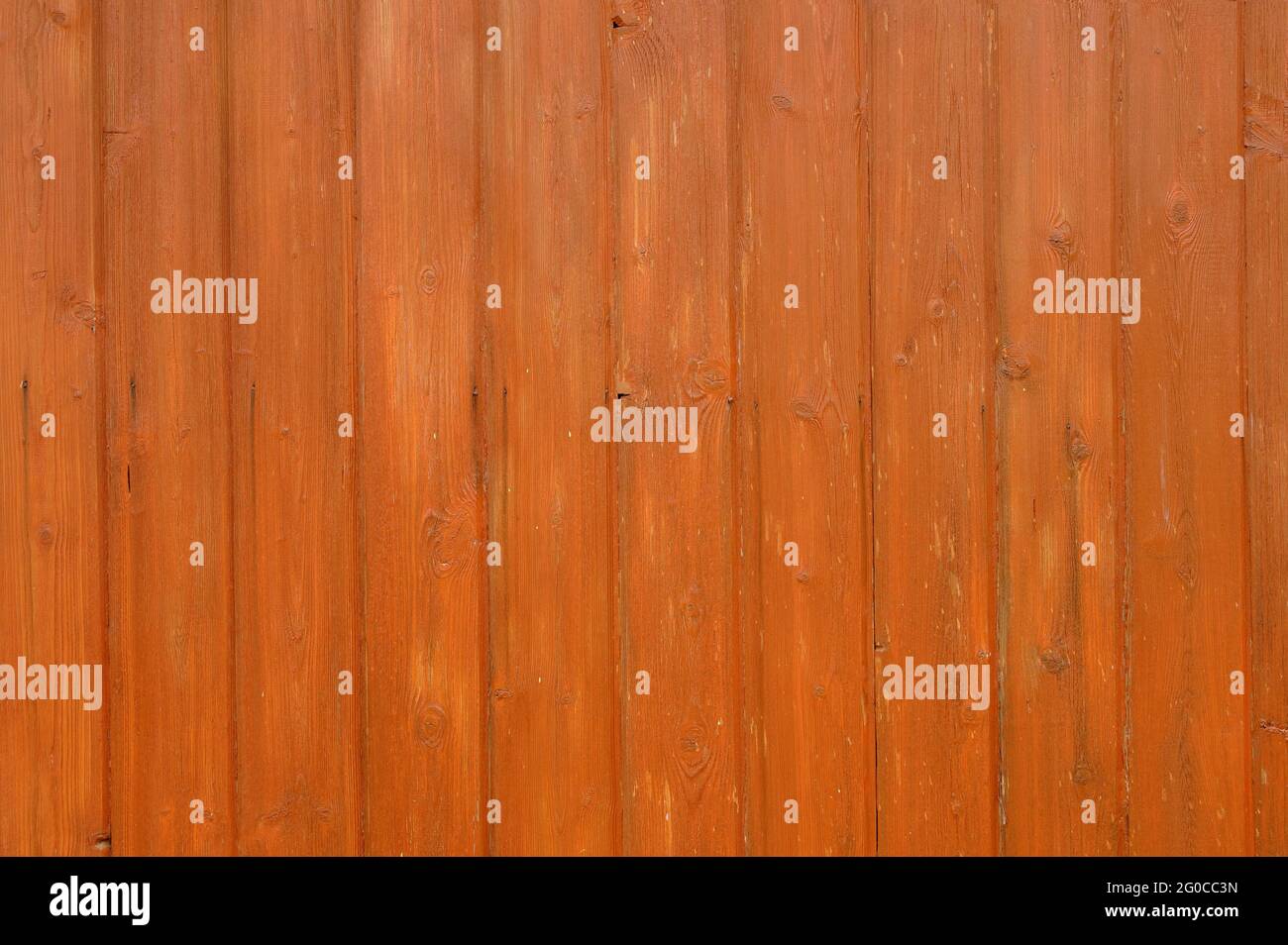 The surface is made of wooden boards with knots, painted in orange with a highlighted texture. Background textures. Stock Photo