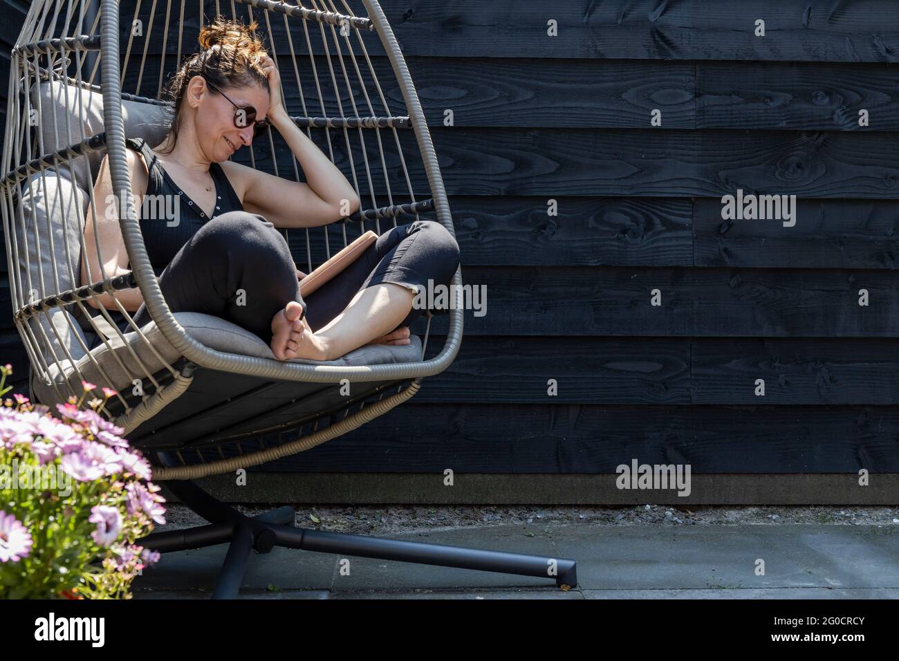Woman relaxing in garden chair hi-res stock photography and images - Alamy