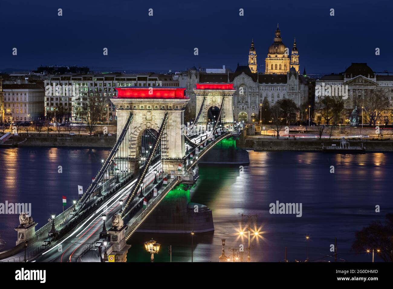 Budapest, Hungary - The world famous illuminated Szechenyi Chain Bridge (Lanchid) by night, lit up with national red, white and green colors with St.S Stock Photo