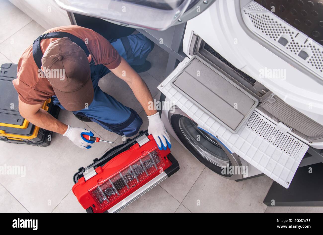Residential Washing Machine Fixing by Caucasian Professional Technician. Home Appliances Issues Theme. Stock Photo