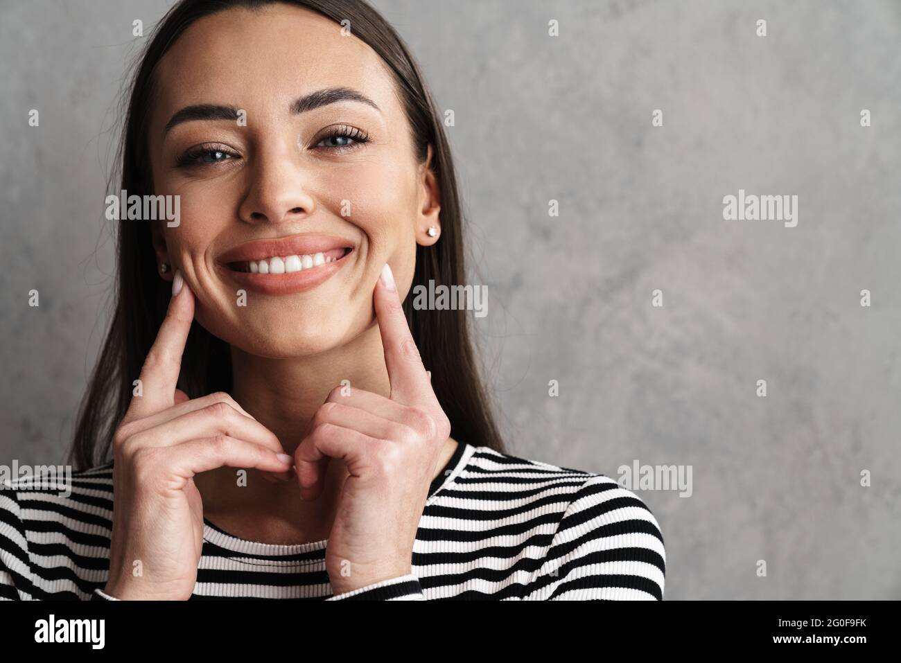 Close up of a beautiful young smiling brunette woman with long hair ...
