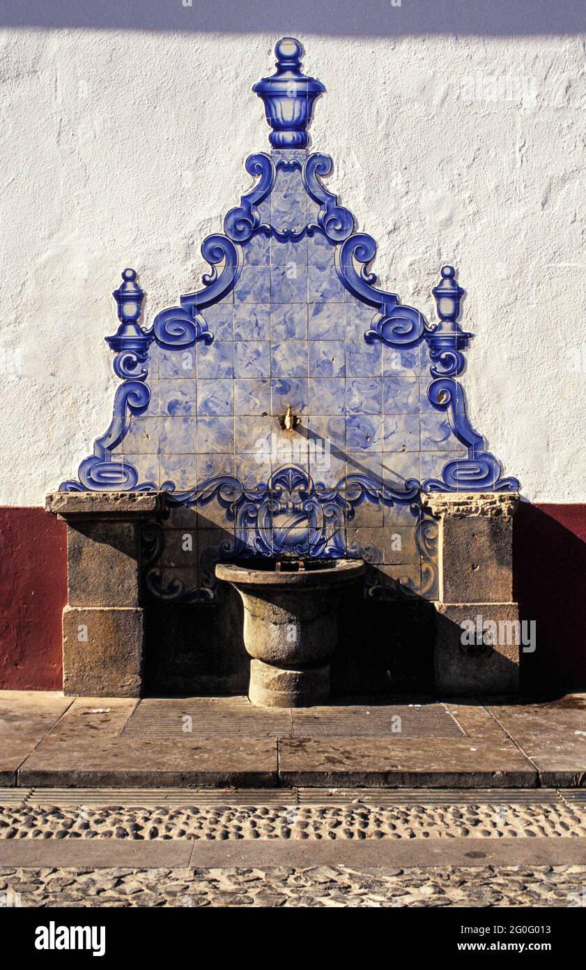 Fountain richly decorated with the typical blue tiles seen in Funchal's oldtown. The glazed tiles, called Azulejos, a centuries old tradition are a common sight on many houses and churches. Stock Photo