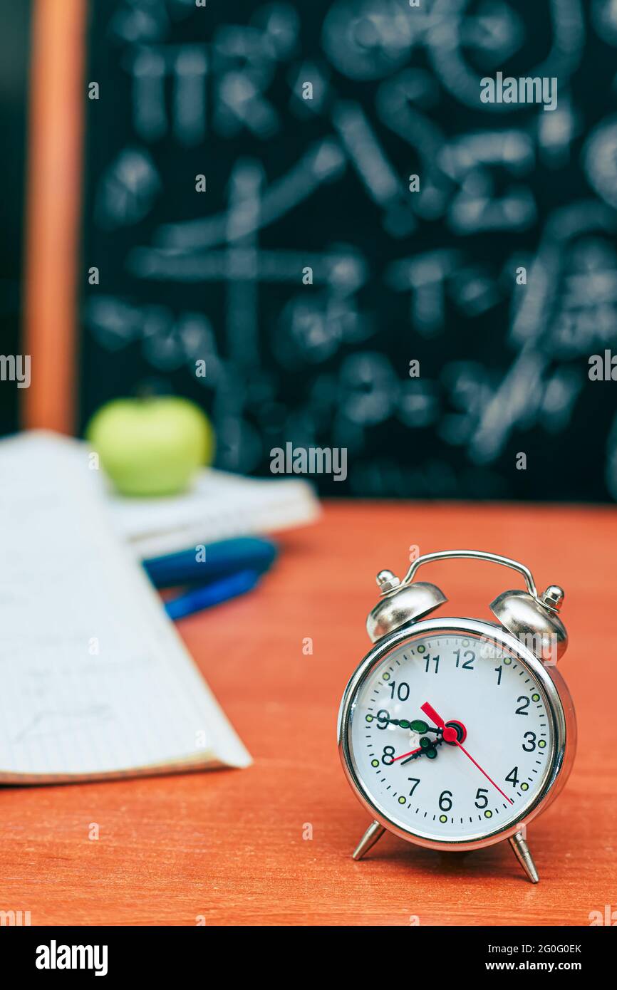 back to school concept, alarm clock on school board background