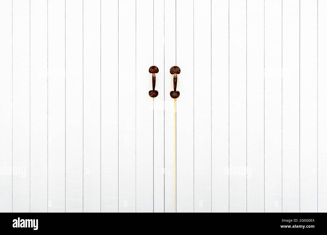 detail image of two rusted pulls on white doors Stock Photo