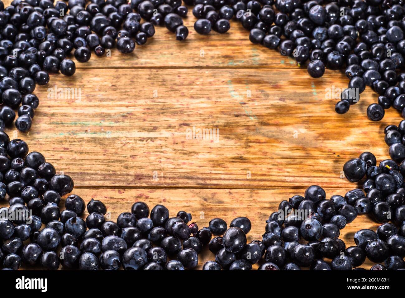 Close-up of blueberries picked in forest located on wooden planks background, background texture Stock Photo