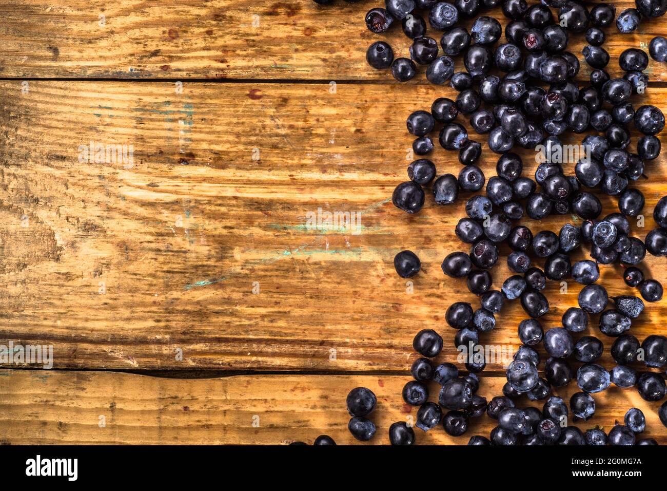 Blueberries picked in forest located on wood background, close-up, background texture Stock Photo