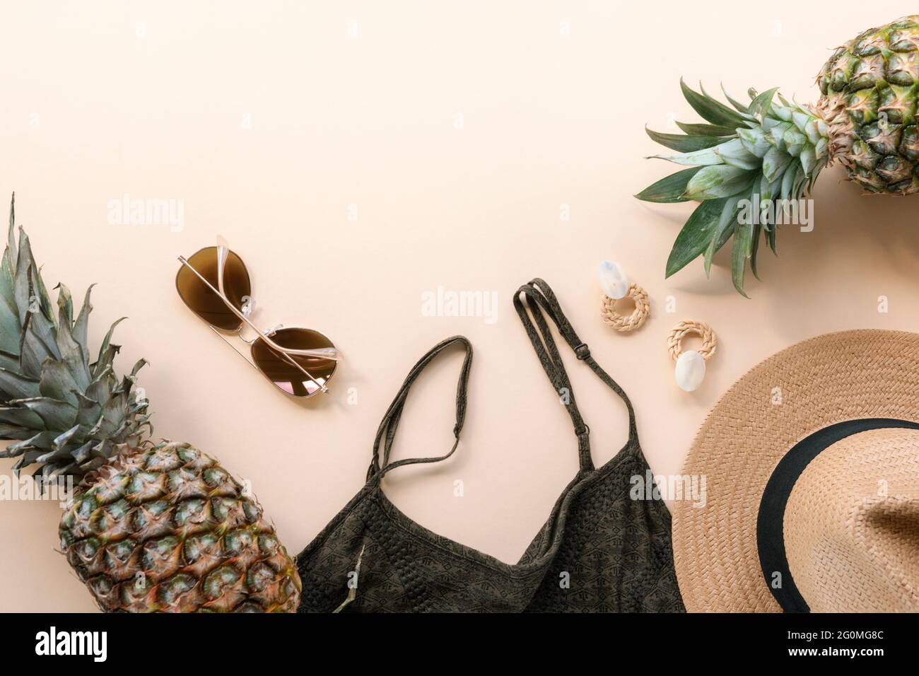Women's summer clothes, accessories and pineapples. Beauty, fashion, summer vacation concept. Top view, flat lay, copy space. Stock Photo