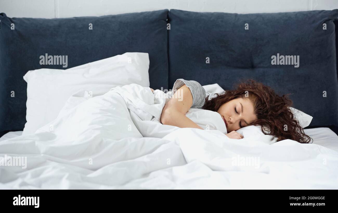 curly young woman sleeping in bed Stock Photo - Alamy