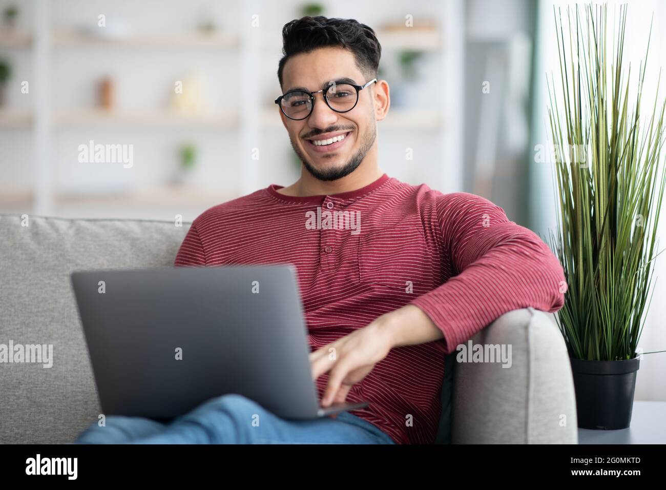 Positive arab man freelancer working from home, using notebook Stock Photo