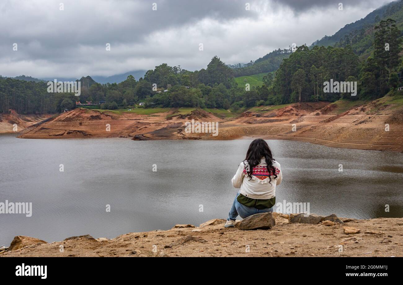 girl thinking and feeling the true nature at lakeside image is taken at munnar kerala india. Stock Photo