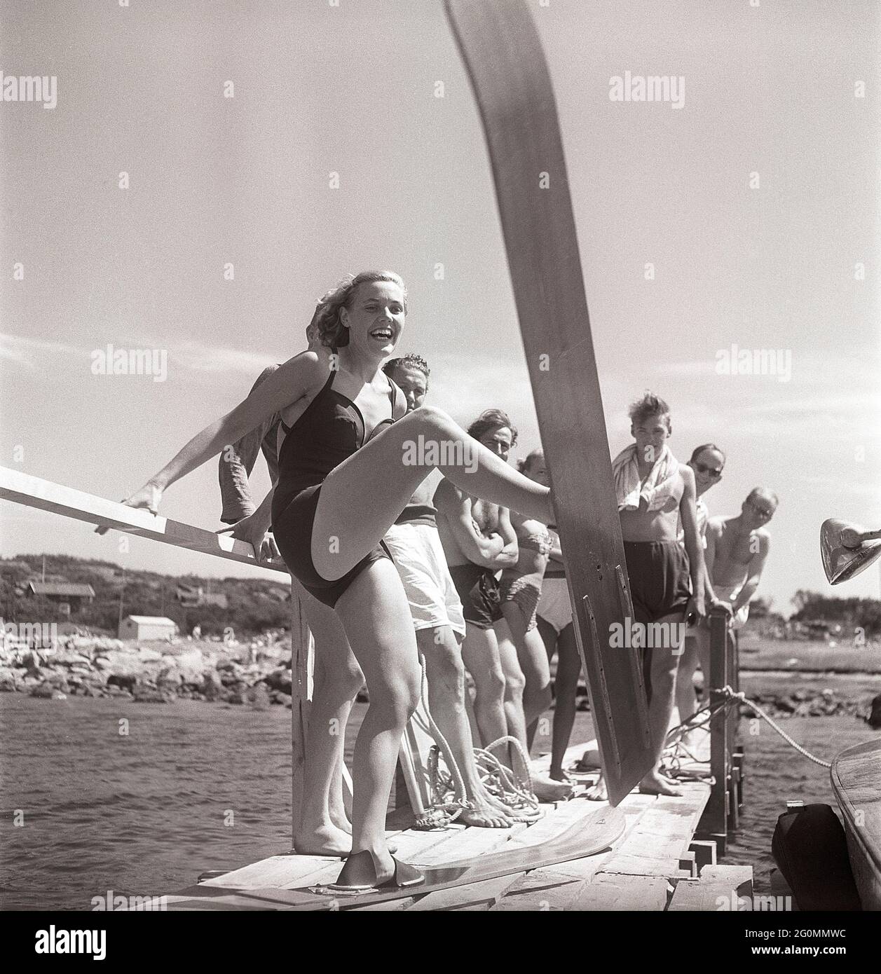 1950s on the beach. A young woman on the seaside is going to try the ...