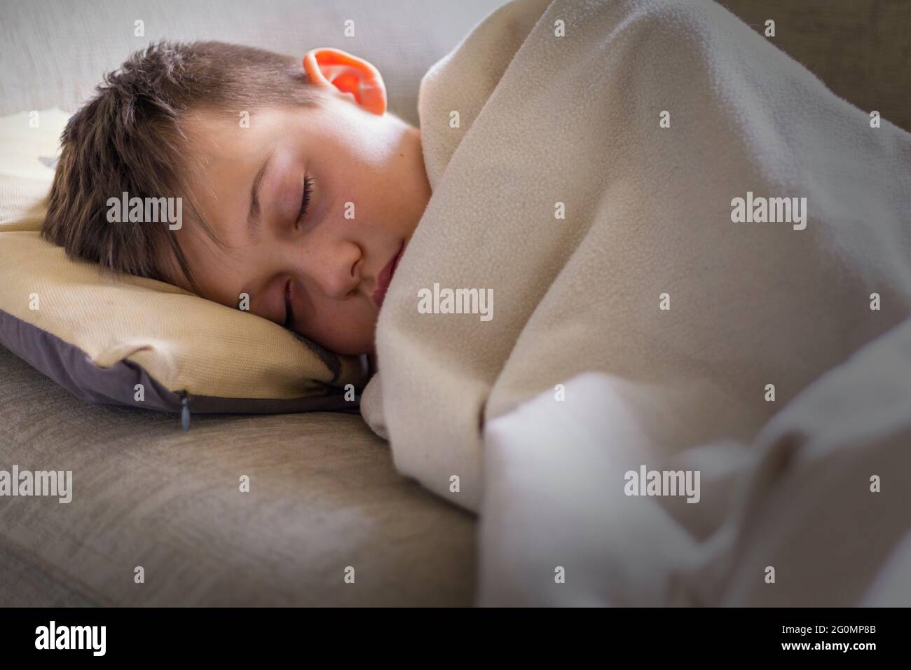 Teenage boy fallen asleep on sofa Stock Photo