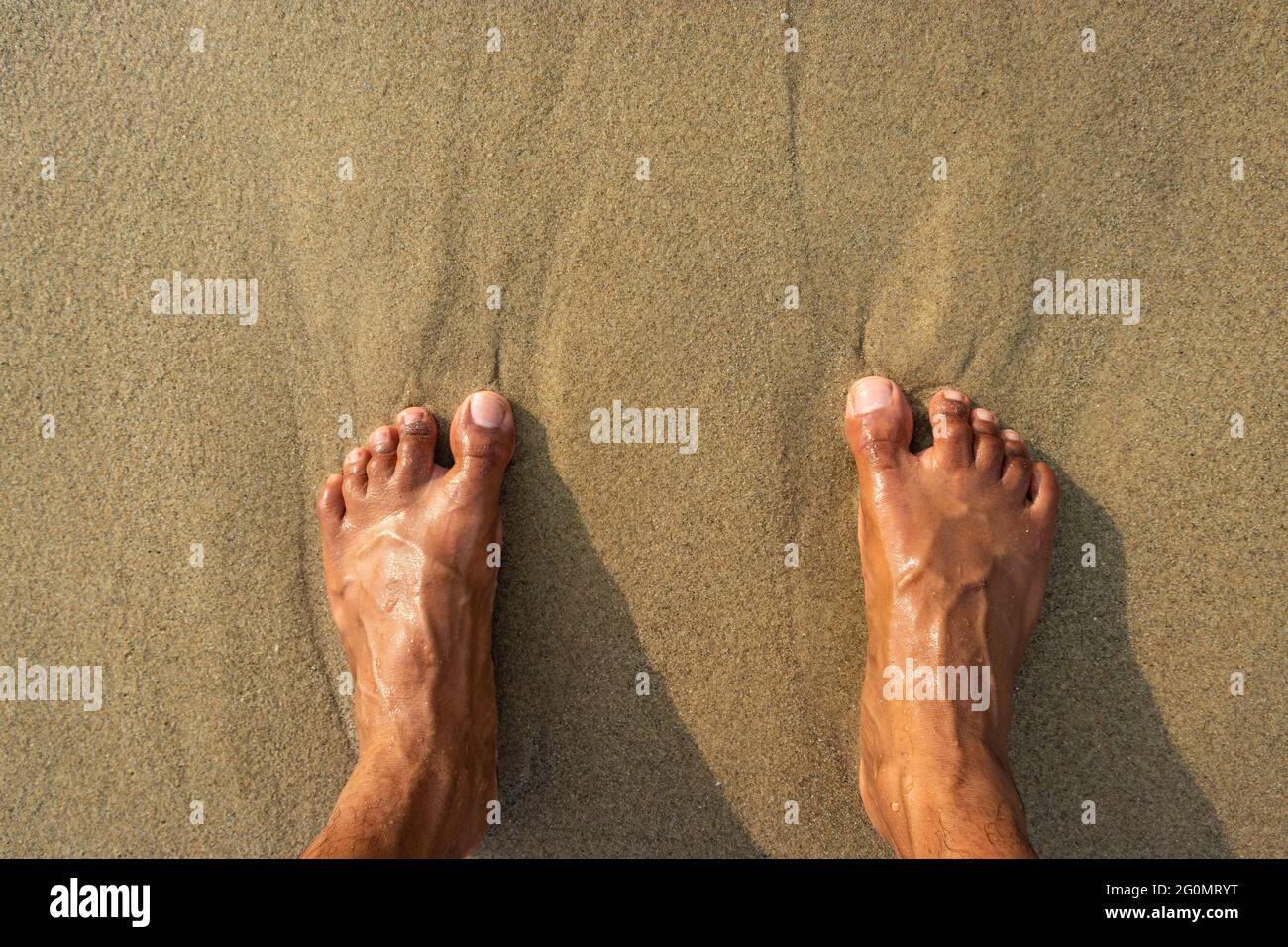 human feet feeling nature isolated on sandy beach showing the human love of nature. The true expression of human life. Stock Photo