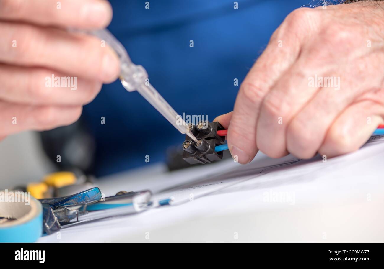 Electrician hands connecting wires in terminal block Stock Photo