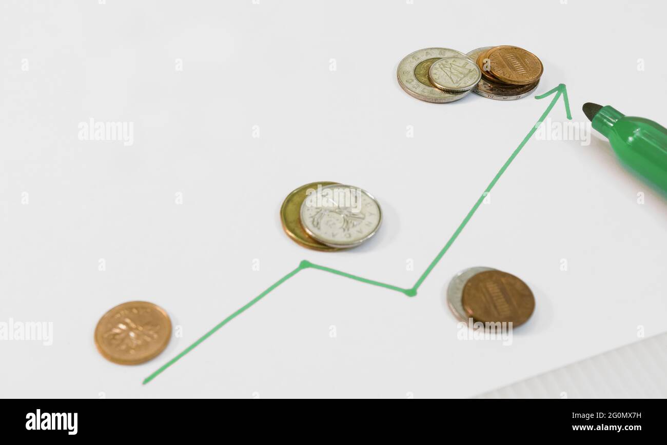 A line drawn with a green marker showing the start of a slight financial growth (currencies, coins). Stock Photo