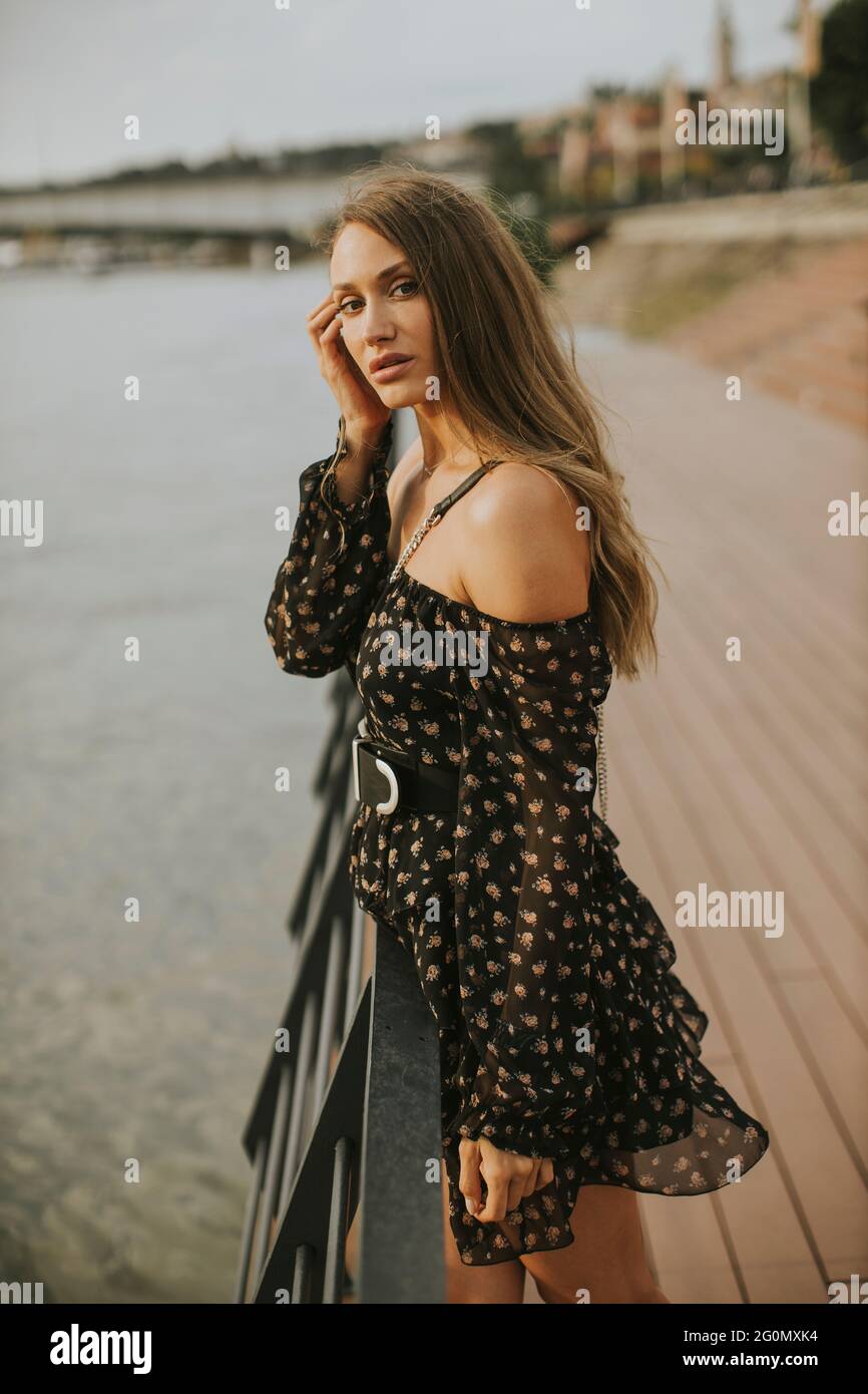 Pretty young long hair brunette woman standing on the riverside Stock ...