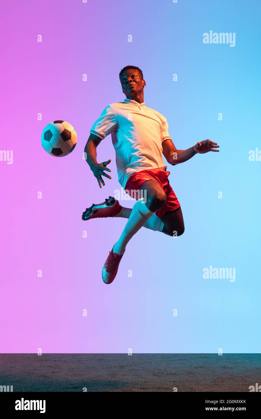 Portrait of African professional football player standing isolated on