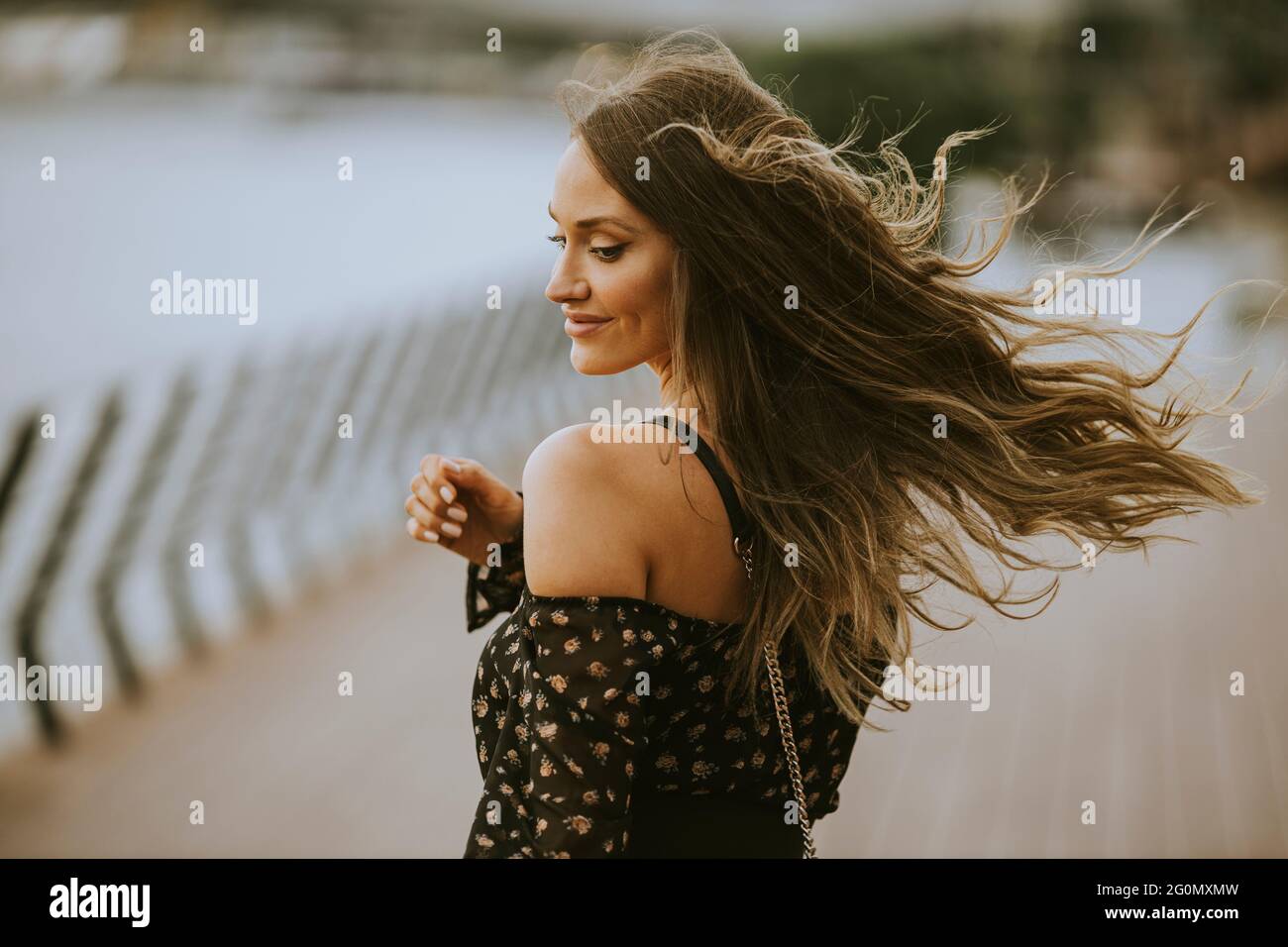 Pretty young long hair brunette woman walking on the riverside Stock ...
