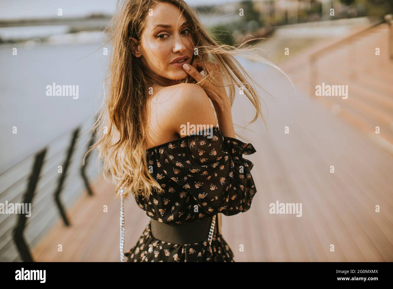 Pretty young long hair brunette woman walking on the riverside Stock ...