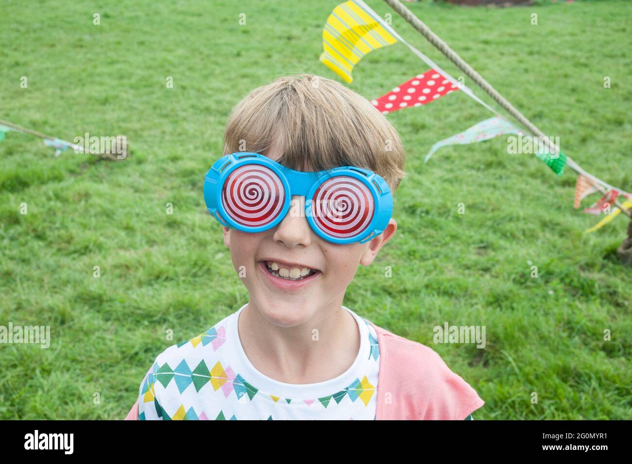 A young boy in festival costume wearing neon Stock Photo