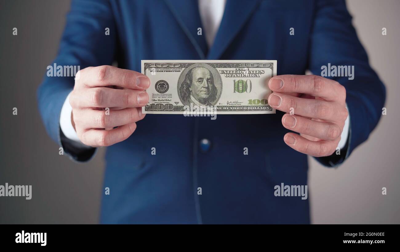 Businessman in blue jacket with dollar in hands Stock Photo
