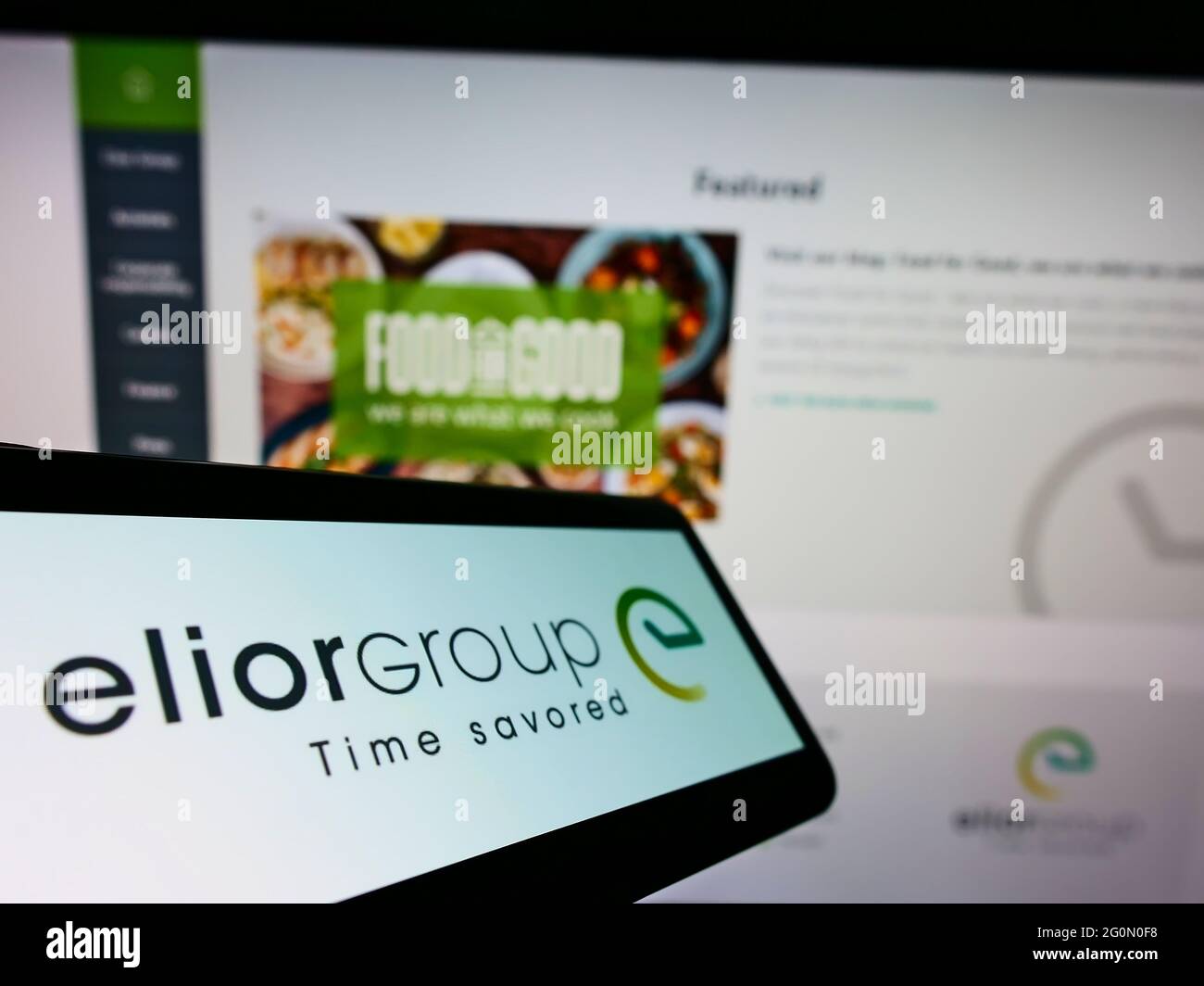 Cellphone with logo of French contract catering company Elior Group on screen in front of business website. Focus on center-right of phone display. Stock Photo