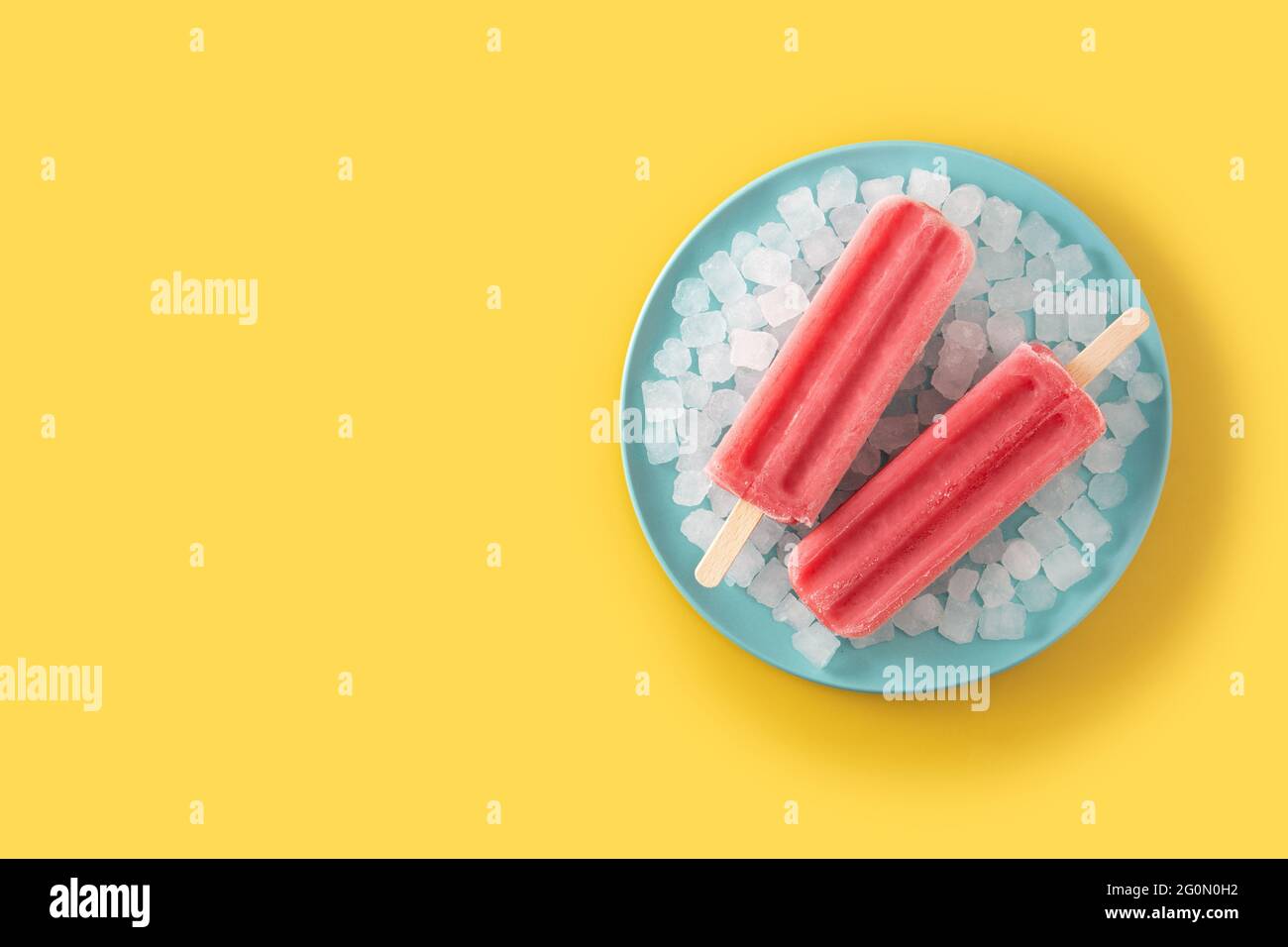 Strawberry popsicles with ice on yellow background Stock Photo