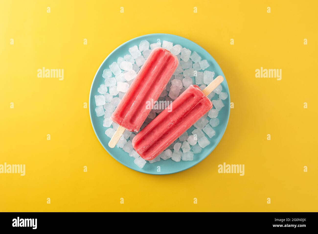 Strawberry popsicles with ice on yellow background Stock Photo