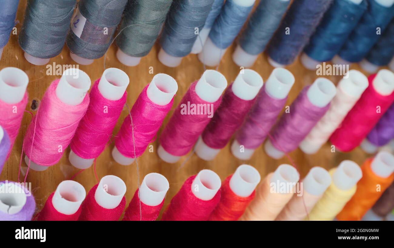 Photo of colourful spools of threads in workshop Stock Photo