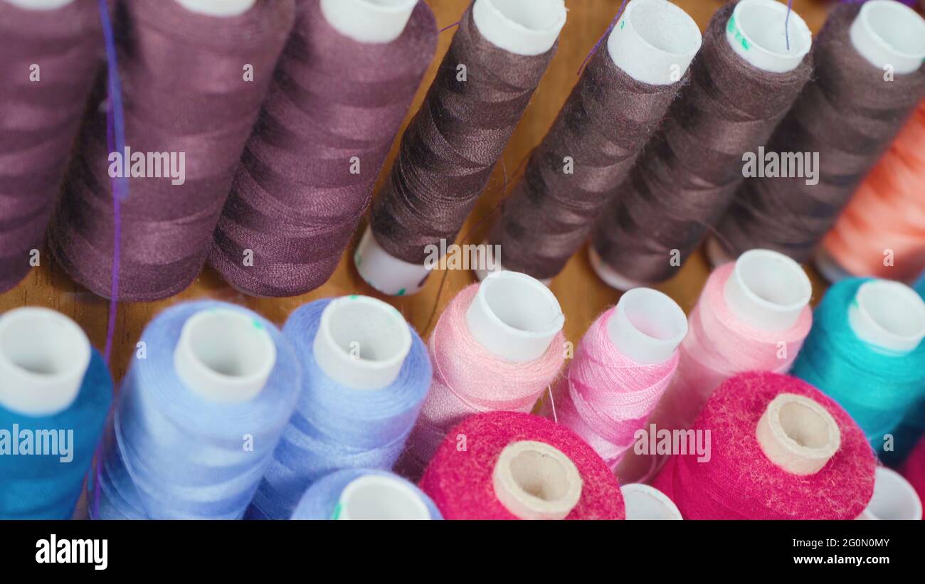 Photo of multicolored spools of cotton threads in workshop Stock Photo