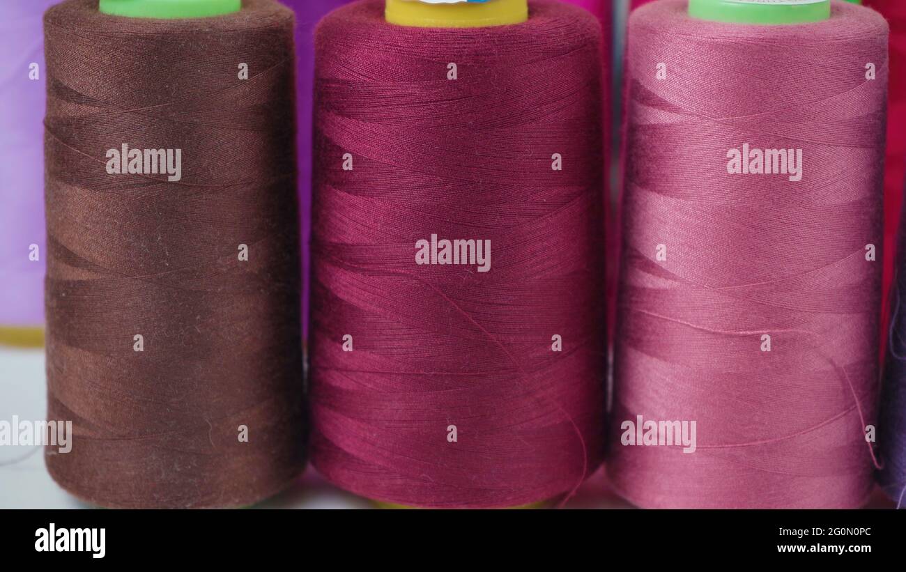 Shooting of colored bobbins of threads in workshop Stock Photo