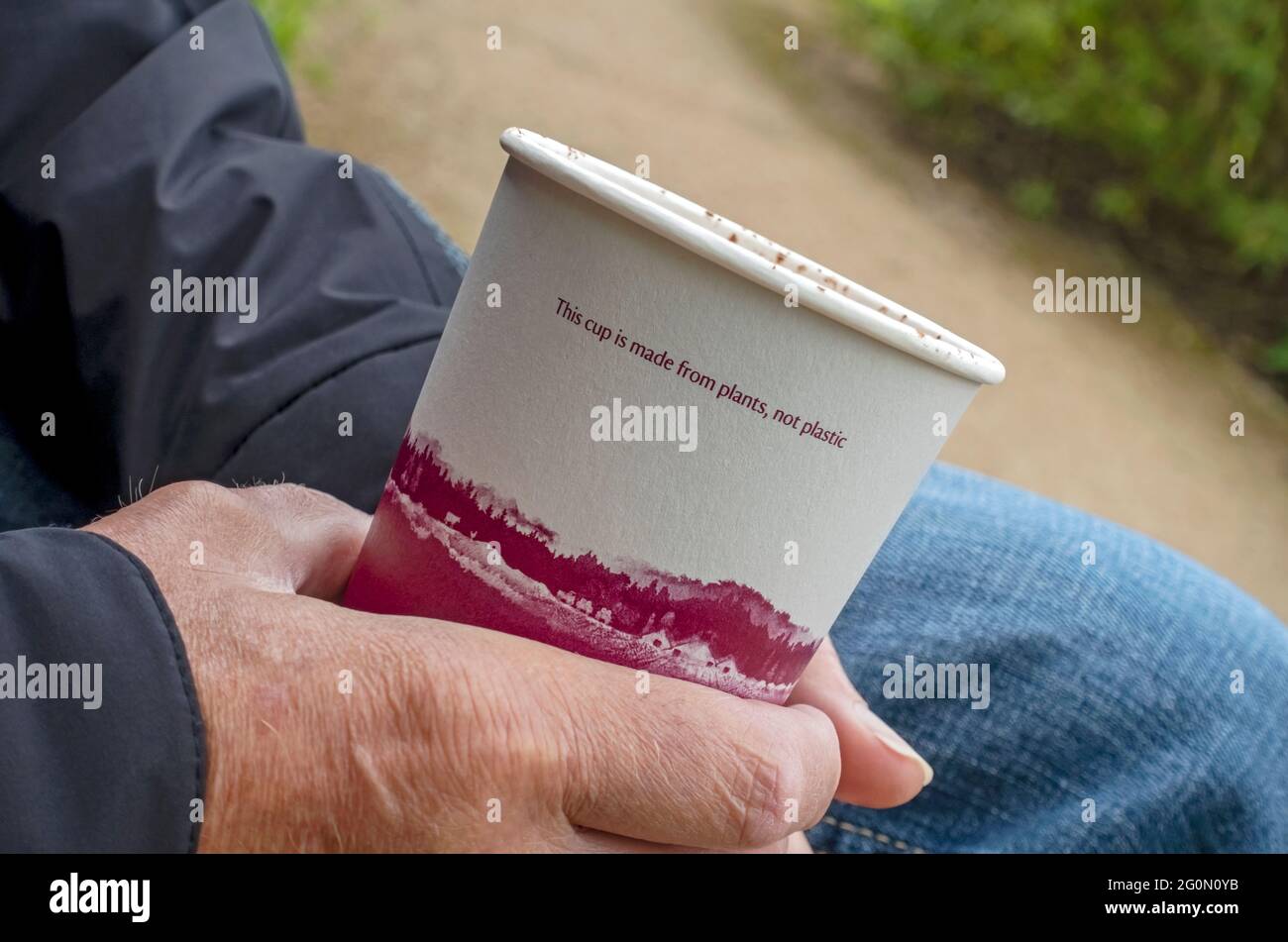 Close up of hand holding disposable drinking drink drinks cup made from plants England UK United Kingdom GB Great Britain Stock Photo