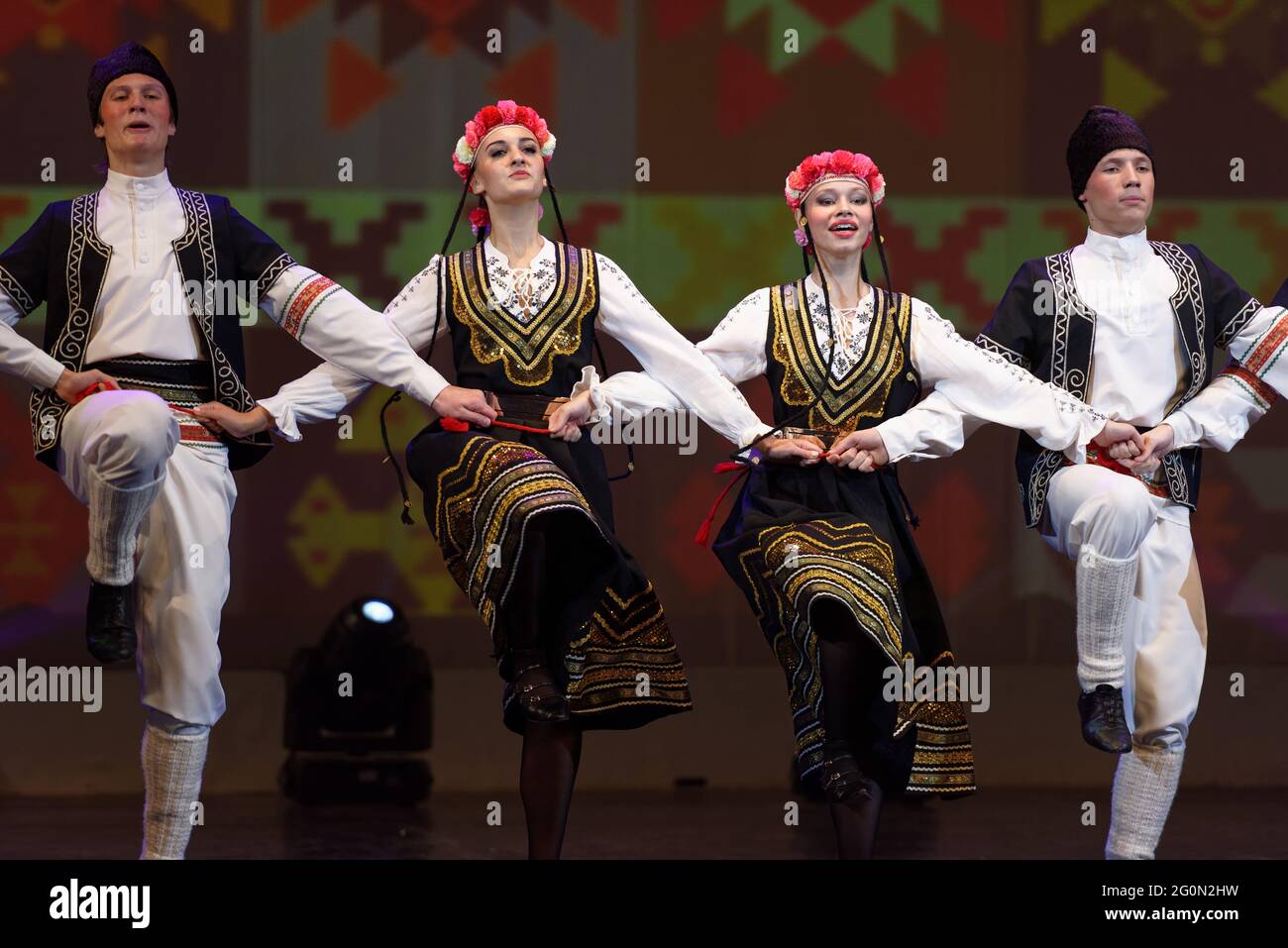 St. Petersburg, Russia - 8th October, 2018: Children dance group in Bulgarian folk costumes performs in the super final of International project 'Fireworks of talents. Choreography'. More than 1300 young dancers take part in the contest Stock Photo