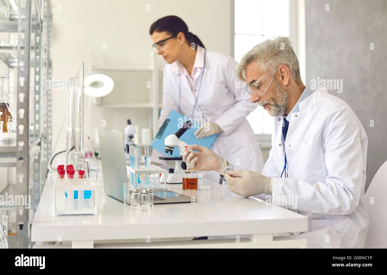 Medical scientists working in laboratory, doing research and using modern lab equipment Stock Photo