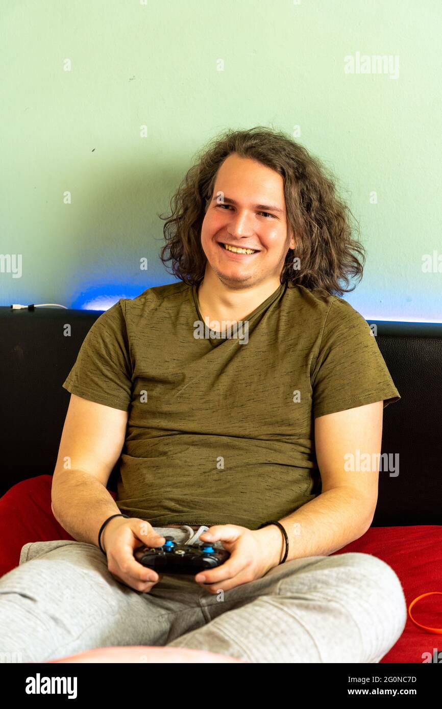 Cheerful guy is playing a video game using a joystick Stock Photo