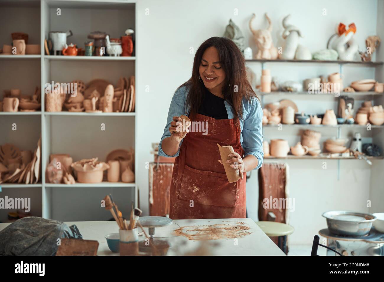 Charming young woman working in pottery workshop Stock Photo