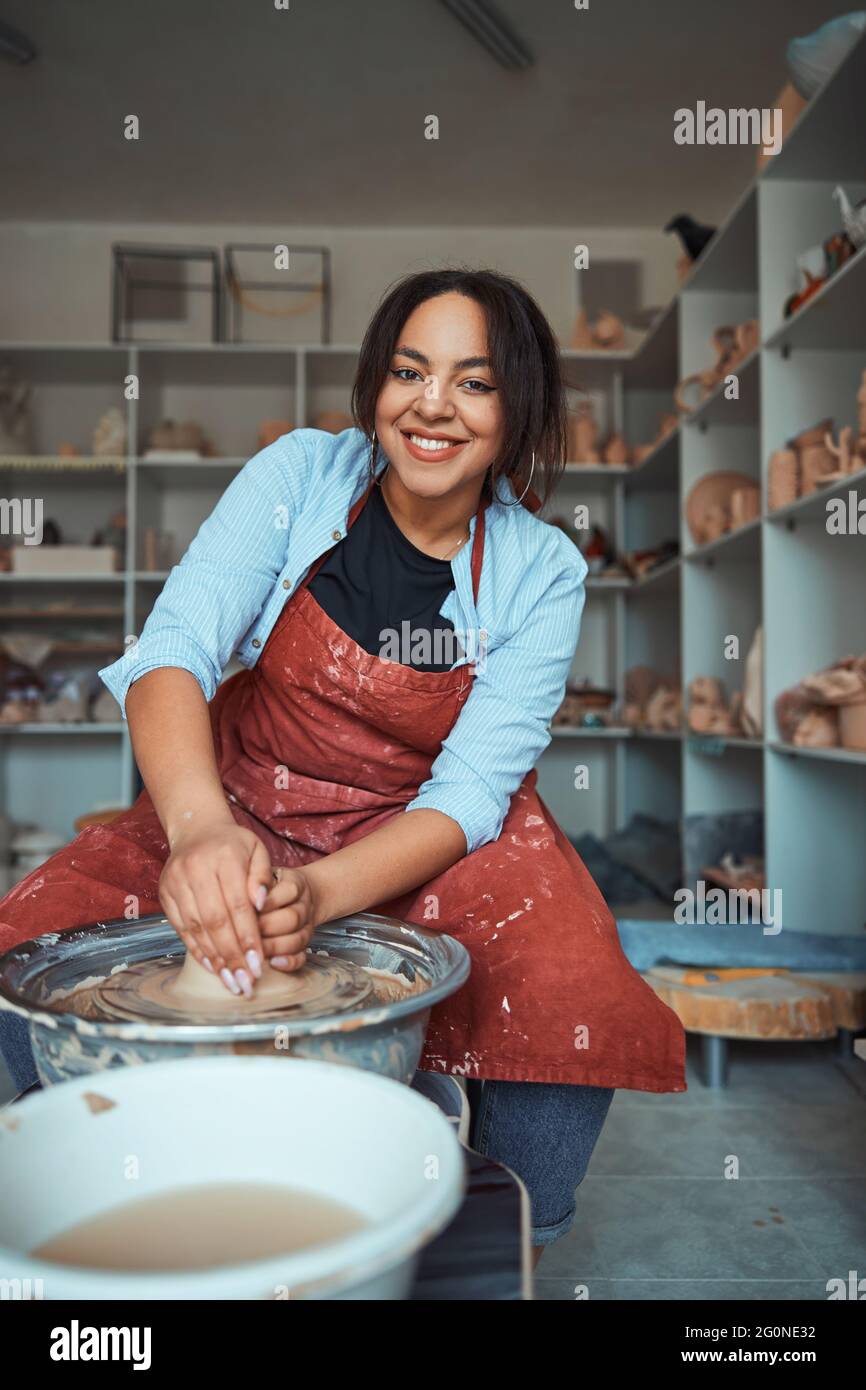 Cheerful female ceramist making pottery in workshop Stock Photo - Alamy