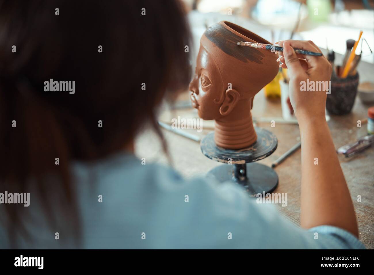Female ceramic artist painting pottery in workshop Stock Photo - Alamy