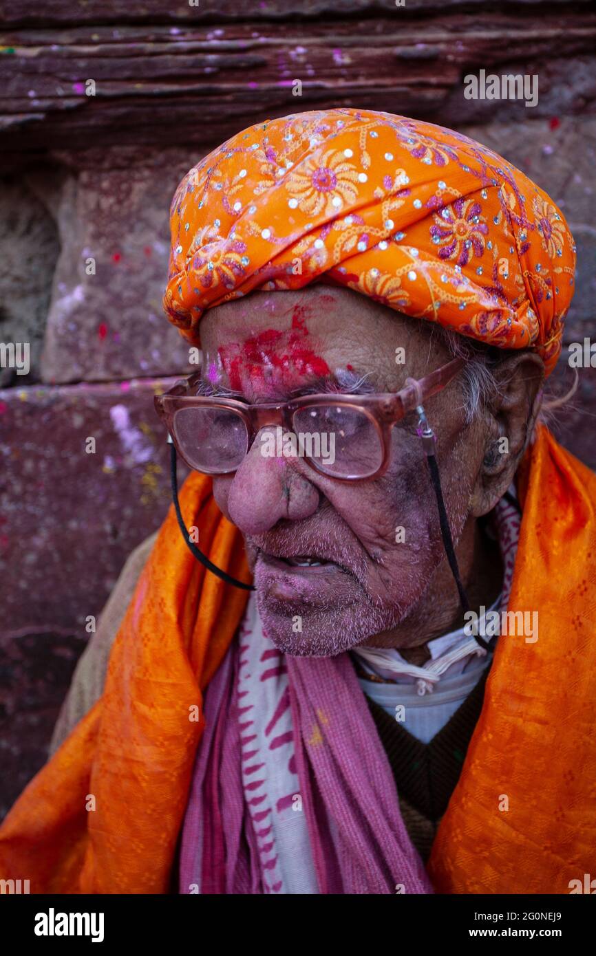 Indian aged man portrait in holi festival face smudged with multicolour powder Stock Photo
