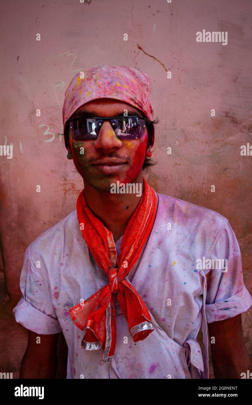 Young Indian man wearing goggles and face smudged with multicolour Stock Photo