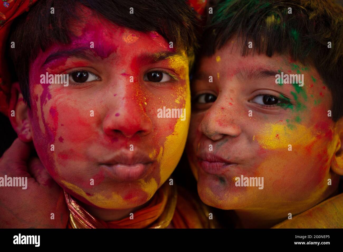 Indian boys making fun in holi festival with face smudged with multicolour Stock Photo